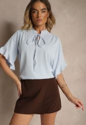 Jasnoniebieska Bluzka z Falbanami i Wiązaniem Fadeassa. Niebieskie bluzki damskie Renee, bez wzorów, bez kołnierzyka, bez ramiączek. Za 44.99 zł.