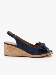 Granatowe sandały na koturnie z kokardą. Niebieskie sandały damskie Ryłko, bez wzorów, ze skóry, z okrągłym noskiem, bez obcasa, na koturnie, bez zapięcia. Za 399.99 zł.