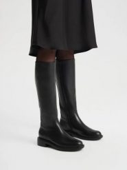 Eleganckie czarne kozaki z wąską cholewką. Czarne kozaki damskie Ryłko, z gumy, z okrągłym noskiem, bez obcasa, na obcasie, bez zapięcia. Za 699.99 zł.