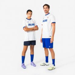 Koszulka piłkarska Anglia 2026 dla kibiców. Białe bluzki damskie KIPSTA, s, bez wzorów, z materiału, sportowe, bez kołnierzyka, bez ramiączek. Za 44.99 zł.