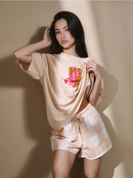 Dwuczęściowa piżama z pieskiem w zimowym szaliku - kremowy. Białe piżamy damskie Sinsay, bez wzorów, bez ramiączek. Za 49.99 zł.