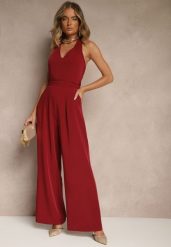 Bordowy Kombinezon o Taliowanym Kroju z Dekoltem Halter i Wiązanym Paskiem Malisena. Czerwone sukienki damskie Renee, bez wzorów, eleganckie, bez ramiączek. W wyprzedaży za 119.99 zł.