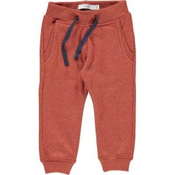 Spodnie dresowe w kolorze rdzawym. Brązowe spodnie niemowlęce Name it, z dresówki. W wyprzedaży za 42.95 zł.