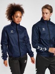 Kurtka ortalionowa piłkarska dla dorosłych Hummel Core XK Spray Jacket. Niebieskie kurtki damskie Hummel, m, bez wzorów, z materiału, z kapturem. Za 178.65 zł.