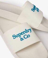 Superdry Klapki Company Logo High Build – Brilliant White/Mid Blue. Białe klapki damskie Superdry, bez wzorów, z gumy, bez obcasa, bez zapięcia. Za 151.45 zł.
