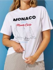Bawełniana koszulka z nadrukiem wakacyjnym Monaco - biały. Białe koszulki damskie Sinsay, l, bez wzorów, z bawełny, bez kołnierzyka, bez ramiączek. W wyprzedaży za 19.99 zł.