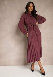 Fioletowa Sukienka Plisowana o Rozkloszowanym Kroju ze Stójką Gumką i Paskiem Zinnoritta. Fioletowe sukienki damskie Renee, bez wzorów, eleganckie, bez ramiączek. W wyprzedaży za 83.99 zł.