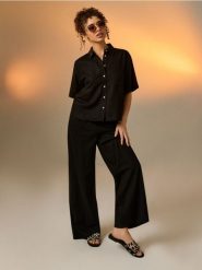 Klapki z motywem zebry ze skórzaną wkładką - czarny. Czarne klapki damskie Sinsay, bez wzorów, bez obcasa, bez zapięcia. Za 49.99 zł.