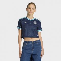 Koszulka wyjazdowa o skróconym fasonie Niemcy 26. Niebieskie bluzki damskie Adidas, bez wzorów, sportowe, bez kołnierzyka, bez ramiączek. Za 369.00 zł.