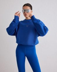 Damska bluza biegowa oddychająca, odprowadzająca wilgoć Le Run błękitna. Niebieskie bluzy damskie Aim'n, s, bez wzorów, z bawełny, bez kaptura. Za 381.00 zł.