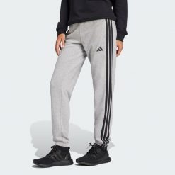 Spodnie Essentials 3-Stripes French Terry Cuffed. Czarne spodnie sportowe damskie Adidas, l, bez wzorów, z bawełny, z standardowym stanem, na fitness i siłownię. Za 219.00 zł.
