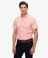 Superdry Koszula Oxford krótki rękaw Rose Pink Chambray z bawełny organicznej. Czerwone koszule damskie Superdry, l, bez wzorów, z bawełny, klasyczne, bez kołnierzyka, bez ramiączek. Za 335.65 zł.