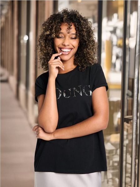 Koszulka z błyszczącym napisem - czarny. Czarne koszulki damskie Sinsay, l, bez wzorów, z bawełny, bez kołnierzyka, bez ramiączek. Za 25.99 zł.