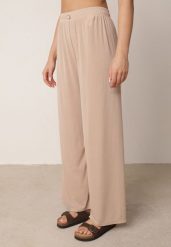 Beżowe Spodnie z Wysokim Stanem i Szerokimi Nogawkami Zdobione Guzikiem Kelesh. Brązowe spodnie materiałowe damskie Born2be, z aplikacjami, z jeansu, długie. Za 49.99 zł.