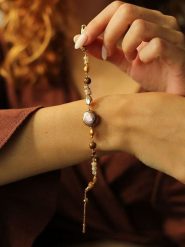 Pierres delicates Pozłacana bransoletka z kamieniami szlachetnymi i perłami rozmiar: onesize. Brązowe bransoletki damskie Pierres delicates, pozłacane. Za 52.99 zł.