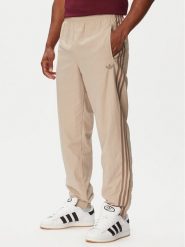 Adidas Spodnie dresowe Firebird KS7503 Beżowy Regular Fit. Brązowe spodnie dresowe damskie Adidas, m, bez wzorów, z dresówki. Za 299.99 zł.