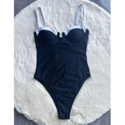 Jednoczęściowy strój kąpielowy z lamówką i wbudowanym stanikiem na lato Aglaja. Czarne stroje jednoczęściowe Intica, bez wzorów, z materiału. Za 169.00 zł.