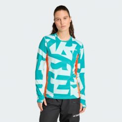 Koszulka z długim rękawem Multi Synthetic Base Layer. Brązowe bluzki damskie Adidas, s, bez wzorów, sportowe, bez kołnierzyka, bez ramiączek. W wyprzedaży za 142.35 zł.