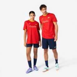 Koszulka piłkarska dla kibiców Hiszpania 2026. Brązowe bluzki damskie KIPSTA, l, bez wzorów, z materiału, sportowe, bez kołnierzyka, bez ramiączek. Za 44.99 zł.