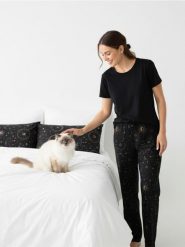 Spodnie piżamowe z szeroką nogawką i motywem kotów i gwiazd - czarny. Czarne piżamy damskie Sinsay, bez wzorów, bez ramiączek. Za 29.99 zł.