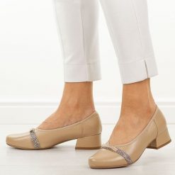 Beżowe czółenka damskie na obcasie Jezzi Asa279-2. Brązowe czółenka damskie Jezzi, z aplikacjami, ze skóry, z okrągłym noskiem, bez obcasa, na obcasie. W wyprzedaży za 179.10 zł.