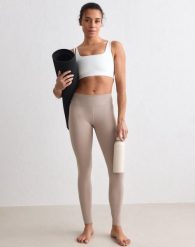 Damskie legginsy szczotkowane, średni stan, pełnej długości Sense ciemna glina. Brązowe legginsy damskie Aim'n, l, bez wzorów, z elastanu. Za 192.40 zł.
