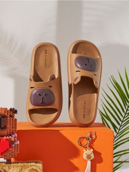 Piankowe klapki z motywem kapibary - beżowy. Brązowe klapki damskie Sinsay, bez wzorów, bez obcasa, bez zapięcia. Za 29.99 zł.