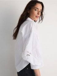 Koszula z ażurowymi rękawami - biały. Białe koszule damskie Reserved, l, w ażurowe wzory, z bawełny, bez kołnierzyka, bez ramiączek. W wyprzedaży za 89.99 zł.