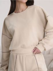 Bluza z ażurowymi detalami - kremowy. Białe bluzy damskie Sinsay, l, w ażurowe wzory, bez kaptura. W wyprzedaży za 24.99 zł.