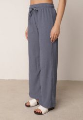 Niebieskie Szerokie Spodnie z Teksturalnej Tkaniny z Wiązaniem w Pasie Agatia. Niebieskie spodnie materiałowe damskie Born2be, bez wzorów, z jeansu, długie. Za 59.99 zł.