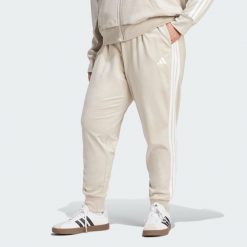 Spodnie Dresowe Essentials 3-Stripes (Dla Sylwetek Plus Size). Białe spodnie dresowe damskie Adidas, plus size, bez wzorów, z dresówki. Za 219.00 zł.