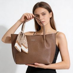 Torebka damska Rieker, ze skóry ekologicznej o prostej eleganckiej formie z ozdobną apaszką przy uchwycie wygodna do noszenia w dłoni i na ramieniu,. Brązowe torebki klasyczne damskie Rieker, ze skóry ekologicznej, na ramię, bez dodatków. Za 279.00 zł.