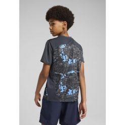 Młodzieżowa koszulka przedmeczowa Manchester City PUMA Strong Gray Cool Light. Szara bluzki damskie Puma, m, bez wzorów, młodzieżowe, bez kołnierzyka, bez ramiączek. W wyprzedaży za 154.00 zł.