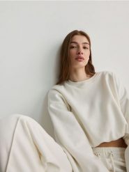 Krótka bluza - złamana biel. Bluzy damskie Reserved, l, bez wzorów, z bawełny, bez kaptura. W wyprzedaży za 69.99 zł.