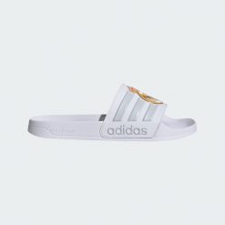 Klapki Adidas Adilette Real Madrid JS4863 - białe, unisex. Białe klapki damskie Adidas, bez wzorów, z materiału, bez obcasa, bez zapięcia. Za 107.99 zł.