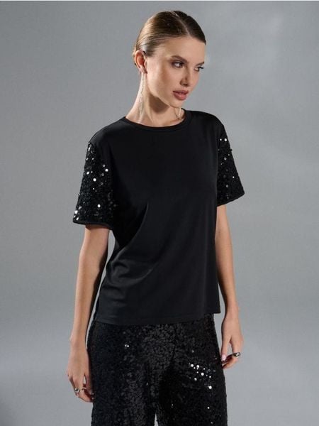 Koszulka z połyskującymi cekinami - czarny. Czarne koszulki damskie Sinsay, l, bez wzorów, bez kołnierzyka, bez ramiączek. Za 39.99 zł.