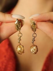 Pierres de Jade Pozłacane kolczyki-wkrętki z perłami rozmiar: onesize. Brązowe kolczyki damskie Pierres de Jade, z perłą, pozłacane. Za 30.99 zł.