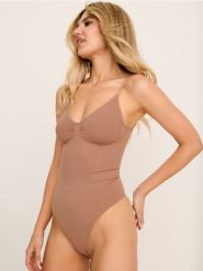 Modelujące body na ramiączkach - kremowy. Białe body i gorsety Sinsay, bez wzorów. Za 39.99 zł.