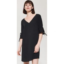 Sukienka oversize z falbaną - Czarny. Czarne kombinezony damskie House. W wyprzedaży za 59.99 zł.