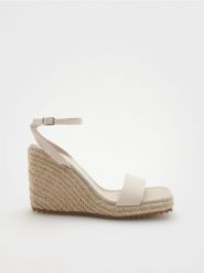 Sandały na koturnie - złamana biel. Sandały damskie Reserved, bez wzorów, ze skóry, bez obcasa, na koturnie, bez zapięcia. W wyprzedaży za 45.99 zł.