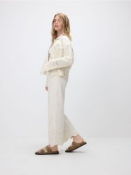 Jeansy wide leg z ażurowym wzorem - kremowy. Białe jeansy damskie Reserved. W wyprzedaży za 109.99 zł.
