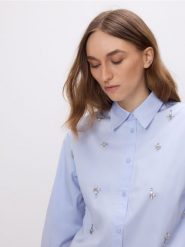 Koszula z błyszczącymi aplikacjami - jasnoniebieski. Niebieskie koszule damskie Reserved, l, z aplikacjami, z bawełny, bez kołnierzyka, bez ramiączek. Za 149.99 zł.