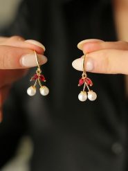 Pierres de Jade Pozłacane kolczyki z perłami i cyrkoniami rozmiar: onesize. Białe kolczyki damskie Pierres de Jade, z cyrkonią, pozłacane, z zapięciem typu bigiel. Za 43.99 zł.