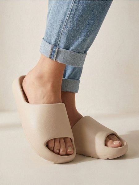 Klapki basic - kremowy. Białe klapki damskie Sinsay, bez wzorów, bez obcasa, bez zapięcia. Za 29.99 zł.