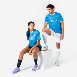 Koszulka piłkarska Włochy 2026 dla kibiców. Białe bluzki damskie KIPSTA, xl, bez wzorów, z materiału, sportowe, bez kołnierzyka, bez ramiączek. Za 44.99 zł.