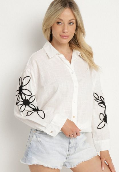 Biała Bawełniana Koszula Oversize z Kwiatowymi Aplikacjami Fadella. Białe koszule damskie Born2be, s, z aplikacjami, z bawełny, eleganckie, bez kołnierzyka, bez ramiączek. Za 89.99 zł.